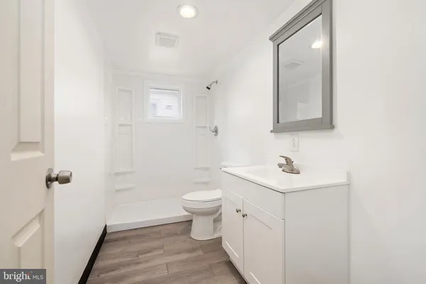 a bathroom with a toilet a sink and mirror