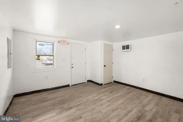 an empty room with wooden floor and window