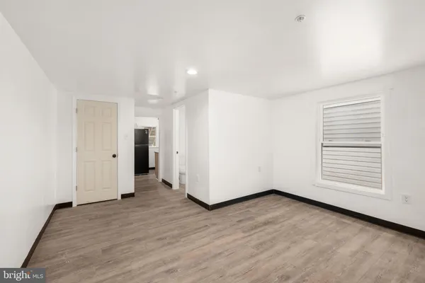 an empty room with wooden floor and white walls