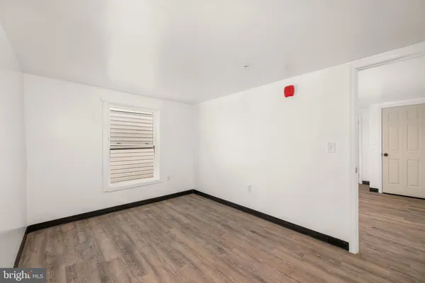 a view of a room with wooden floor and white walls