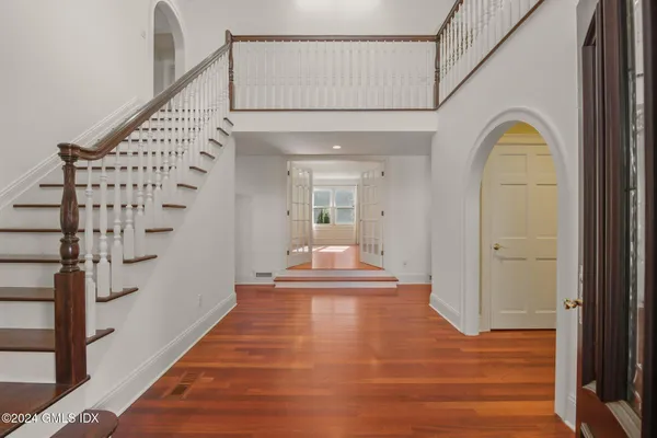a view of a hallway with entryway wooden floor and front door