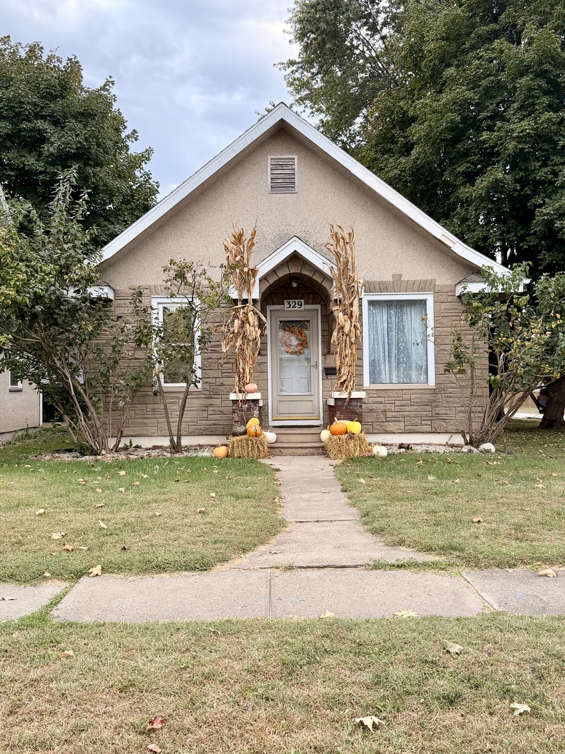 329 West Devlin Street Spring Valley, IL 61362 - Photo 1 of 11 a view of a white house with a big yard and large trees