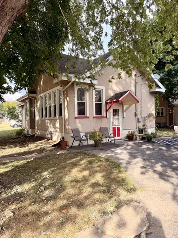 a view of a white house with a large tree