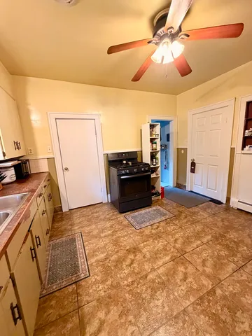 a kitchen with kitchen island a stove a refrigerator and a stove