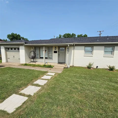 a front view of a house with a garden and yard