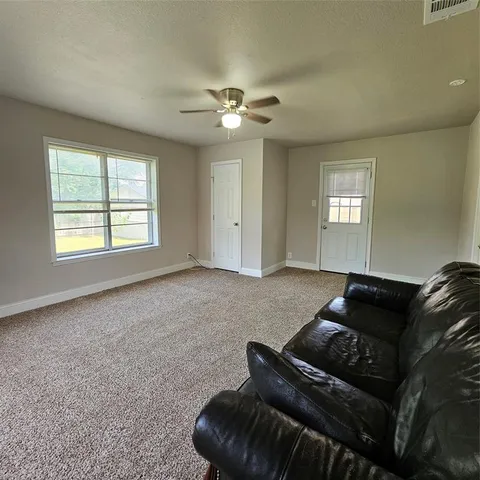 a living room with furniture and a ceiling fan