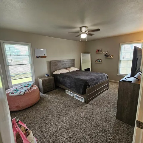 a bedroom with a bed couch and window