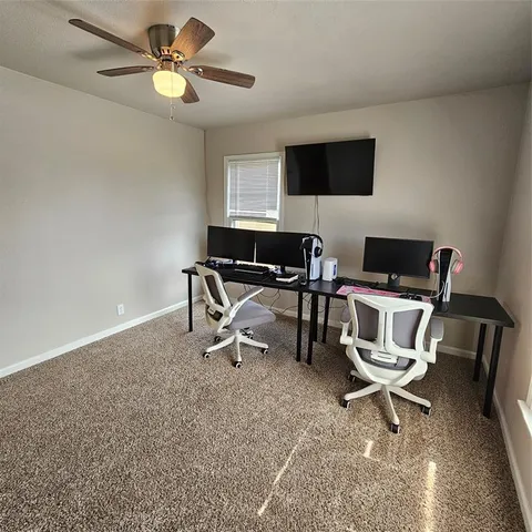 a workspace with a flat screen tv and a ceiling fan