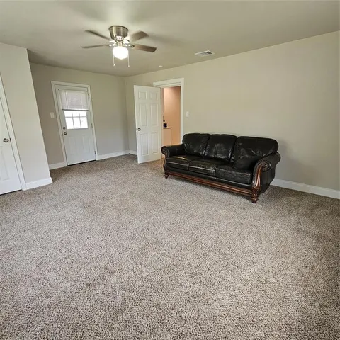 a living room with furniture and a ceiling fan