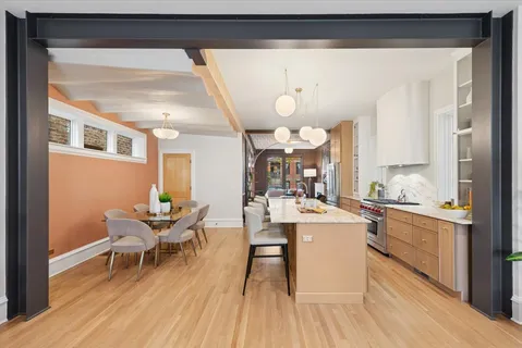 a kitchen with a dining table chairs and white cabinets