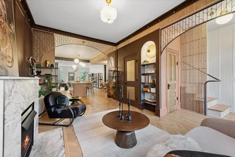 a living room with furniture fireplace and a large window