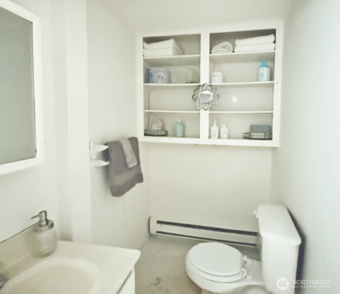 1202 West Perry Street Aberdeen, WA 98520 - Photo 13 of 35 a white toilet sitting next to a bathroom sink