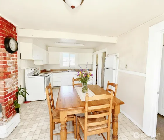 a view of a dining room with furniture and a kitchen view
