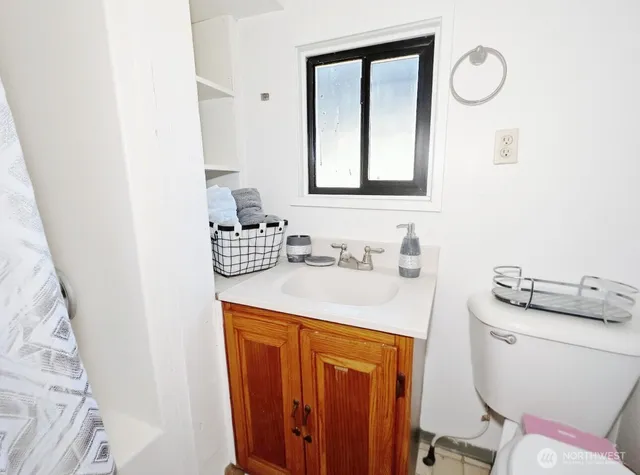 a bathroom with a sink vanity mirror and toilet