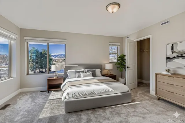 a spacious bedroom with a large bed and windows