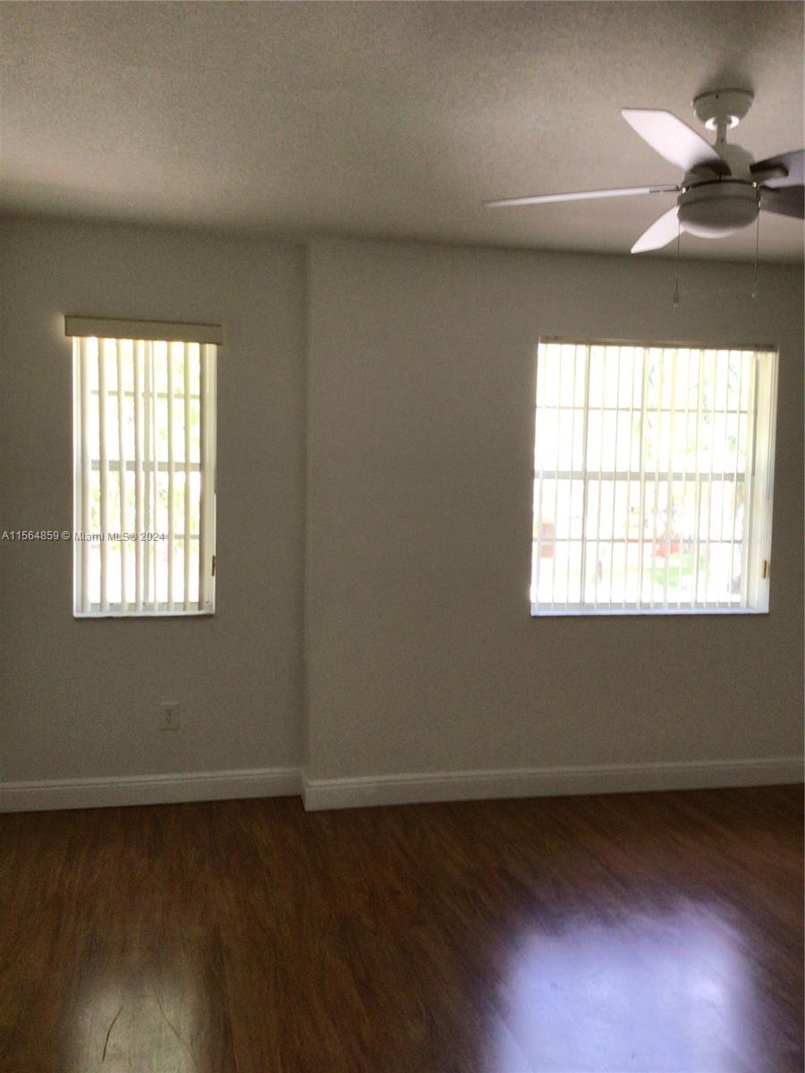 4941 Southwest 135th Way Miramar, FL 33027 - Photo 6 of 11 an empty room with wooden floor and windows