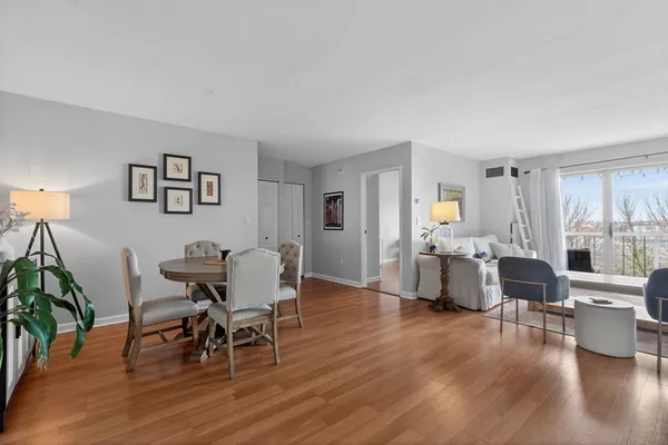 a living room with furniture dining table and wooden floor