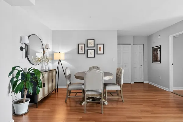 a dining room with furniture potted plants and wooden floor