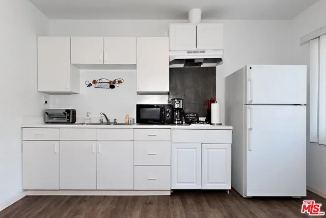 a kitchen with stainless steel appliances white cabinets and a refrigerator