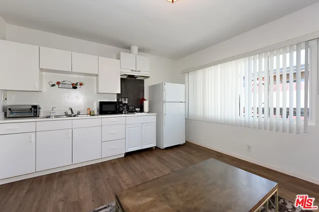 a kitchen with cabinets a window and stainless steel appliances
