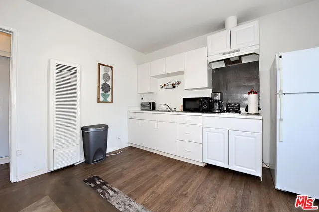a kitchen with stainless steel appliances a refrigerator sink and cabinets
