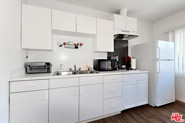 a kitchen with white cabinets and appliances