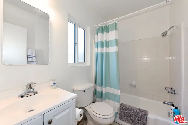 a bathroom with a sink toilet vanity and shower