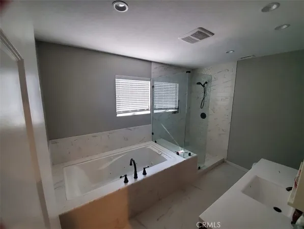 a bathroom with a tub a sink and a window