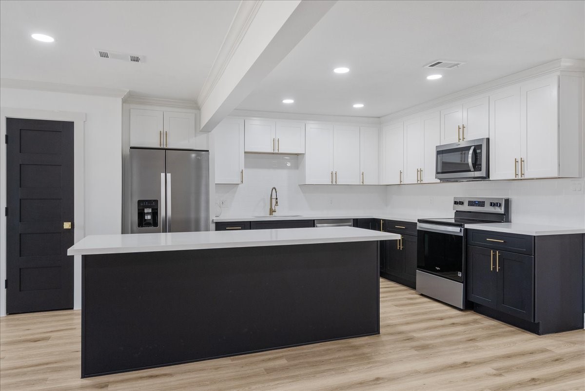 5219 Cosby Street Houston, TX 77021 - Photo 14 of 50 A kitchen that rivals a gallery. Custom white shaker cabinetry meets midnight contrast and sleek hardware, anchored by luminous quartz countertops and stainless steel.