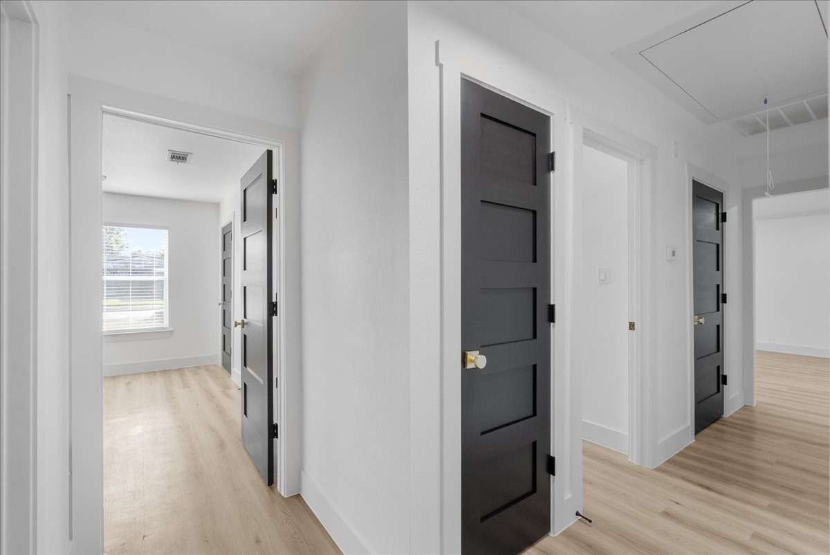 5219 Cosby Street Houston, TX 77021 - Photo 26 of 50 A study in contrast. Bold, obsidian-toned doors pop against a crisp white palette, creating a rhythmic transition to the private quarters.