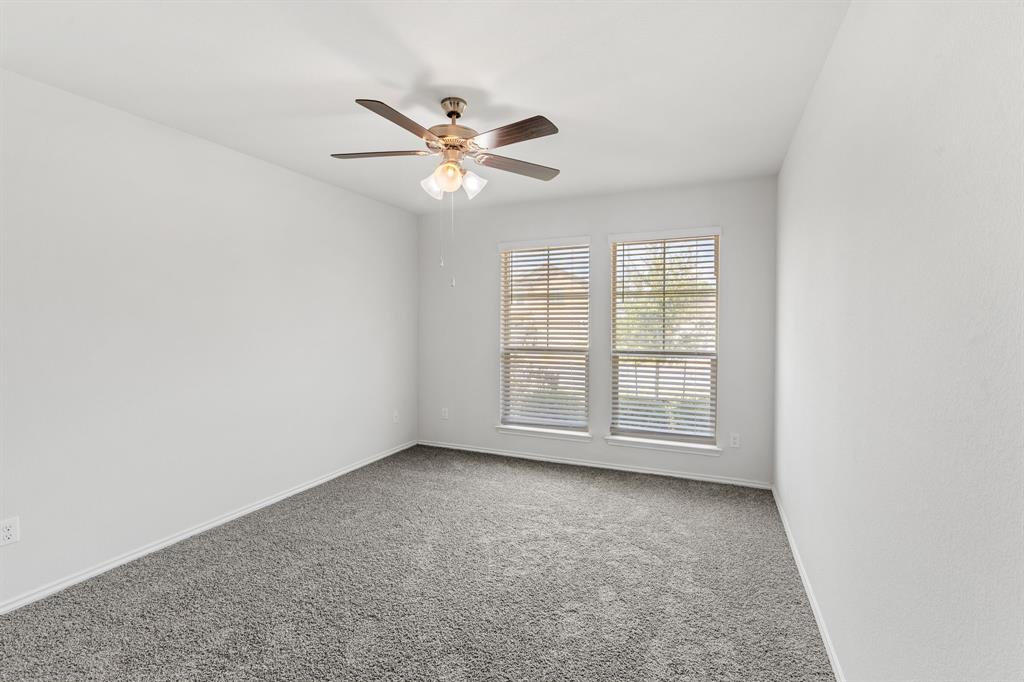 11101 Beckon Waco, TX 76708 - Photo 28 of 35 White walls, gray carpeting, two windows with blinds, and a ceiling fan with integrated lighting