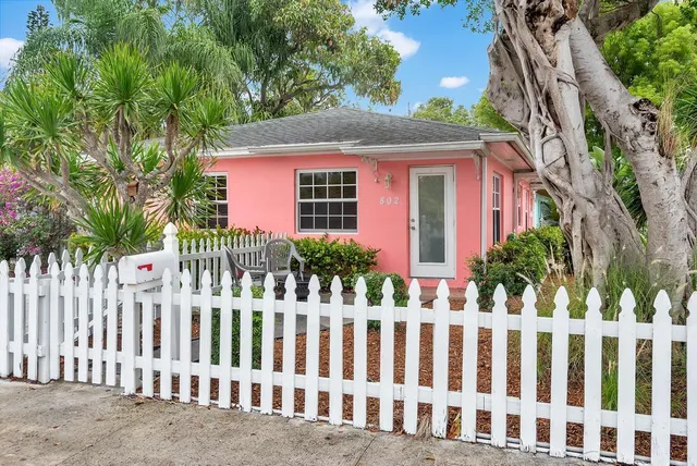 a front view of white house with a garden