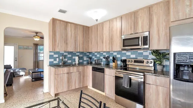 a kitchen with stainless steel appliances a stove a sink cabinets and a kitchen island