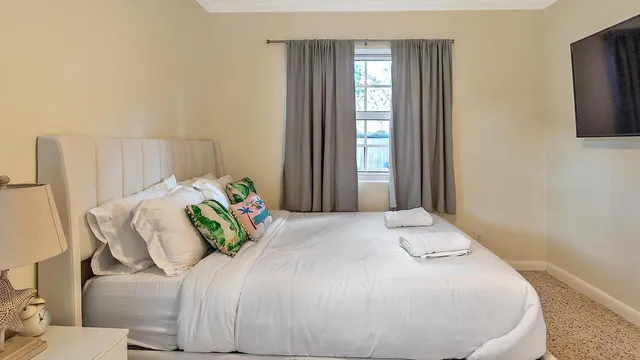 a bedroom with a bed and large windows