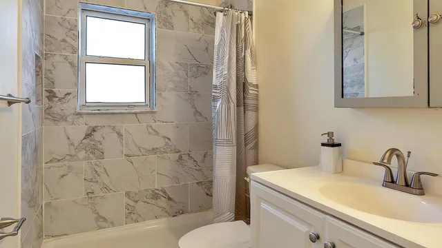 a bathroom with a sink a toilet and shower