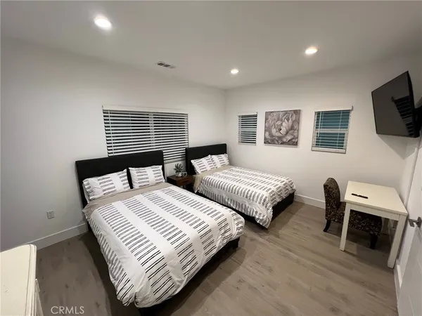 a bedroom with two beds and a television