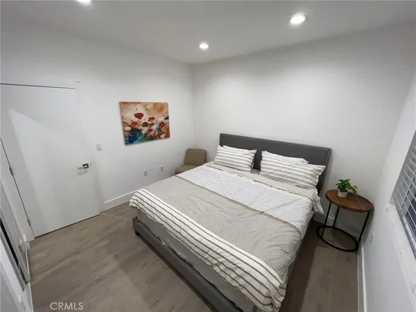 a bedroom with a bed and a painting on the wall