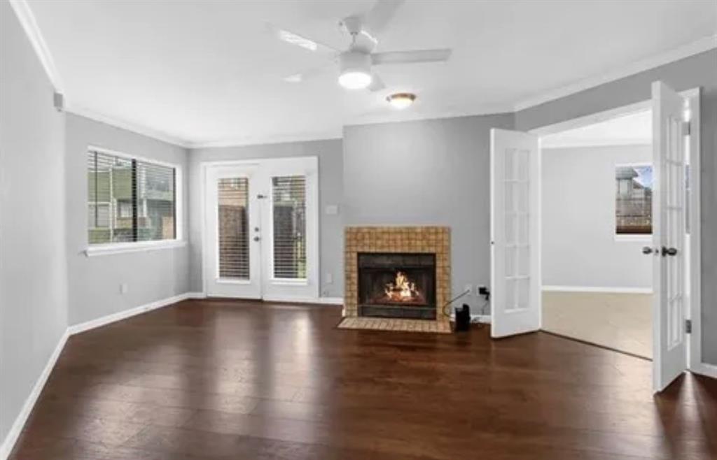 9839 Walnut Street, Unit 201 Dallas, TX 75243 - Photo 3 of 11 an empty room with wooden floor a fireplace and windows