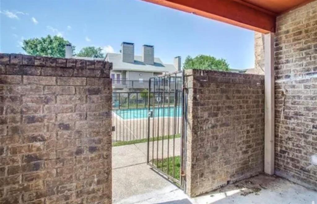 9839 Walnut Street, Unit 201 Dallas, TX 75243 - Photo 4 of 11 a view of a brick wall from a corridor
