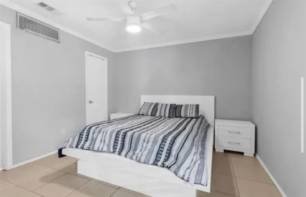9839 Walnut Street, Unit 201 Dallas, TX 75243 - Photo 7 of 11 a bedroom with a bed and a ceiling fan