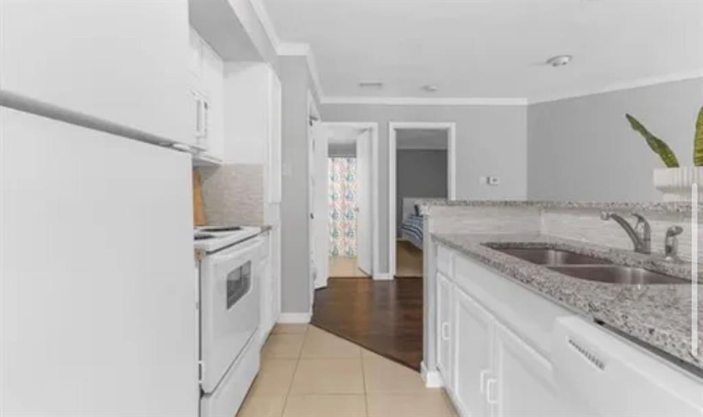 9839 Walnut Street, Unit 201 Dallas, TX 75243 - Photo 9 of 11 a kitchen with granite countertop a sink stove and refrigerator