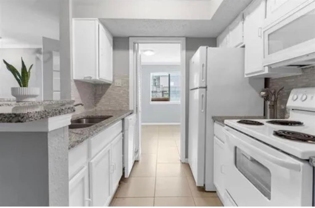9839 Walnut Street, Unit 201 Dallas, TX 75243 - Photo 10 of 11 a kitchen with stainless steel appliances granite countertop a sink stove and refrigerator