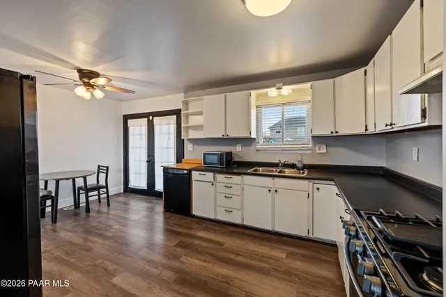 a kitchen with granite countertop a stove a sink a dining table and chairs