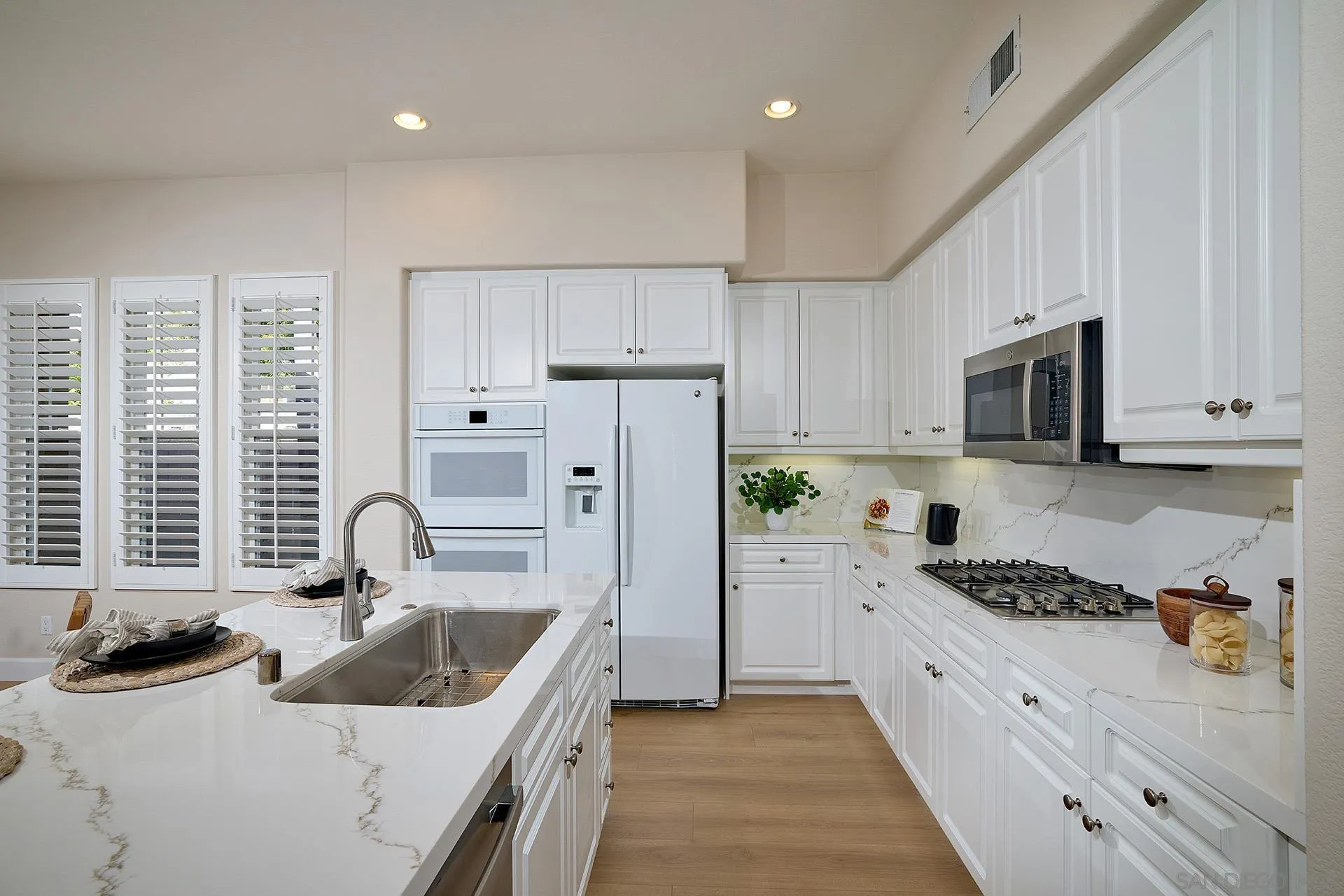 6109 Paseo Tesoro Carlsbad, CA 92009 - Photo 13 of 34 a kitchen with stainless steel appliances granite countertop a sink stove refrigerator and cabinets