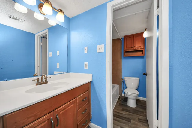 a view of a swimming pool with lawn chairs under an umbrella