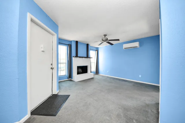 a view of an empty room with a fireplace and a window