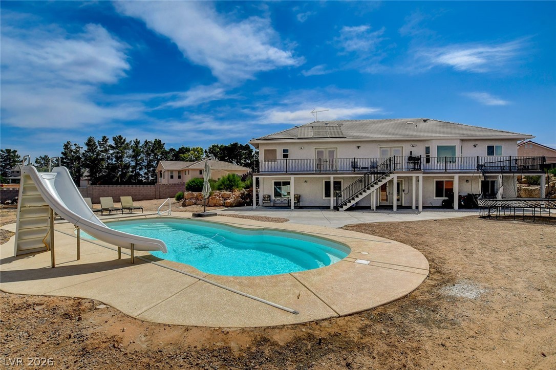 4362 Thistle Street Logandale, NV 89021 - Photo 84 of 99 Backyard oasis with a refreshing pool, slide, and a two-story residence offering ample outdoor living space.