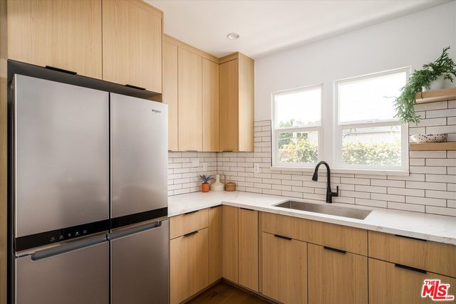 a kitchen with a sink a refrigerator and window