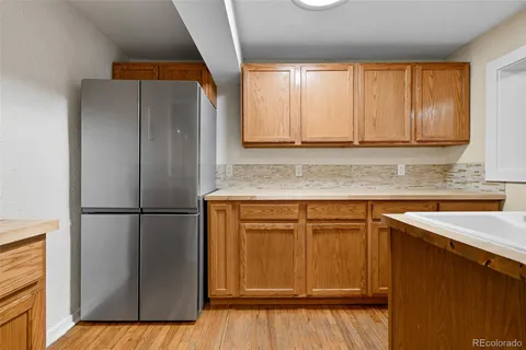 a kitchen with a refrigerator sink and cabinets