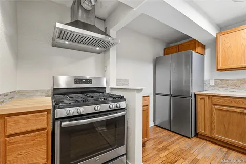 a kitchen with stainless steel appliances granite countertop a stove a refrigerator and a microwave